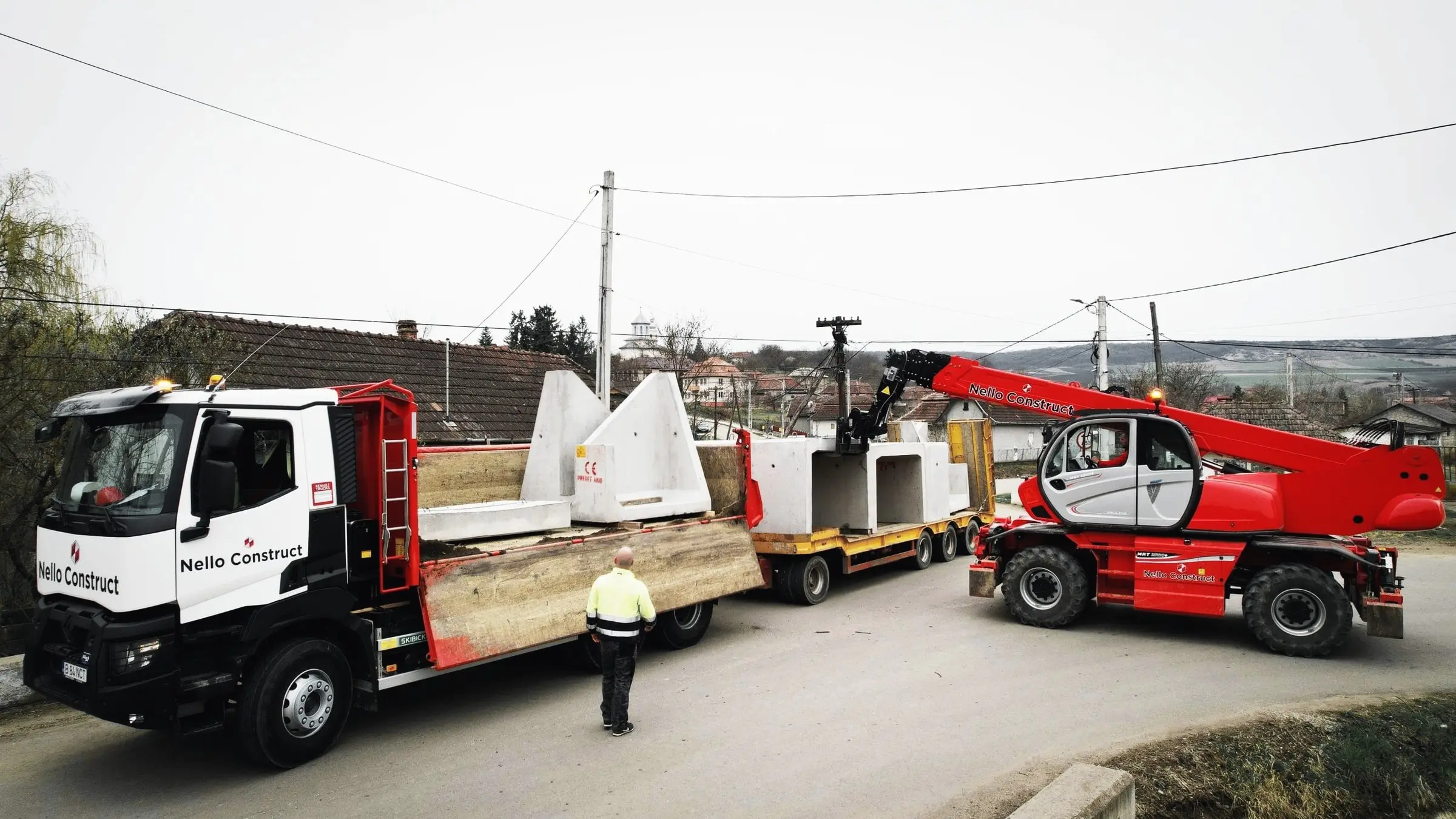 Camion Nello Construct cu elemente prefabricate din beton și manipulator telescopic roșu