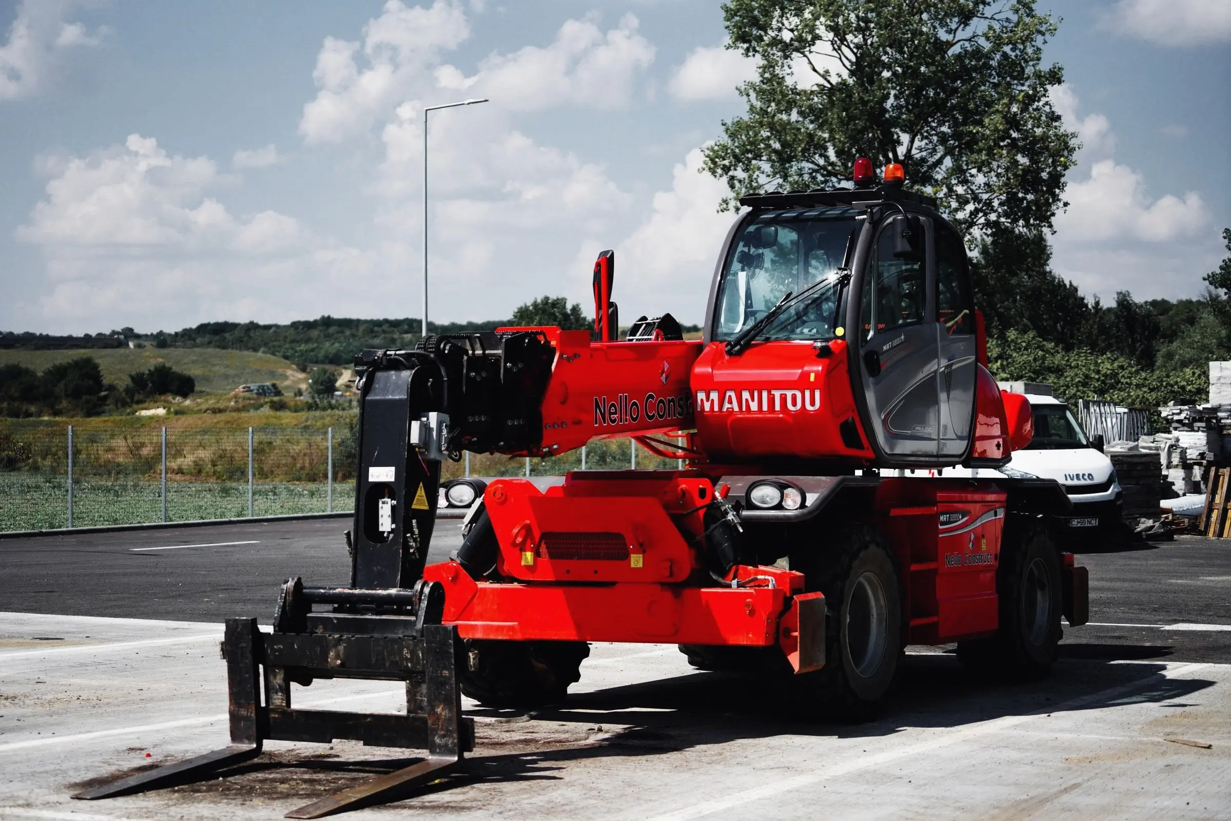 Manipulator telescopic rotativ roșu Manitou cu furci, văzut din față
